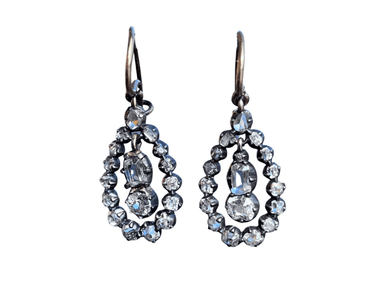 A pair of earrings with a diamond in the middle.