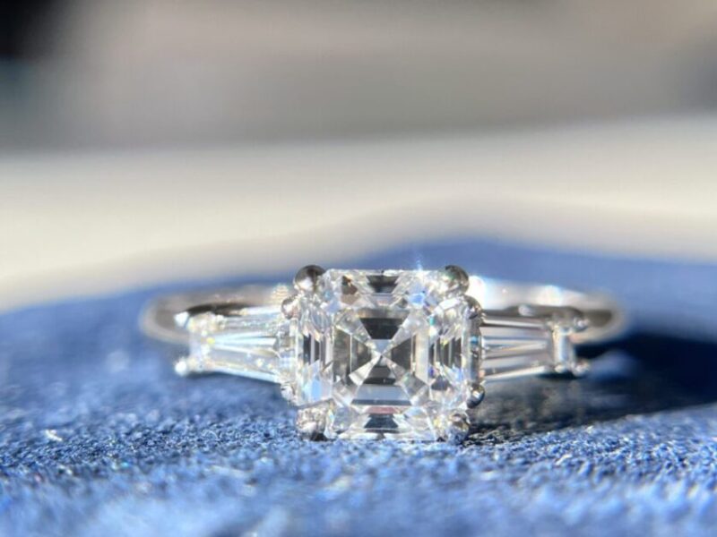 Diamond engagement ring on blue fabric.