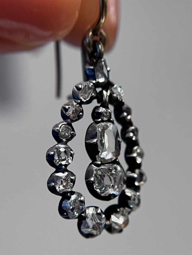 Elegant diamond-studded silver earring in sunlight.