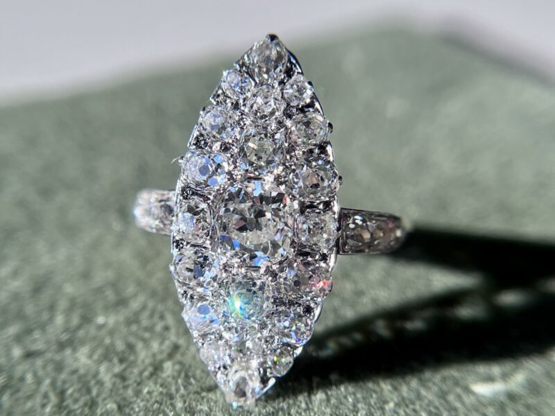 Marquise diamond ring on textured surface.