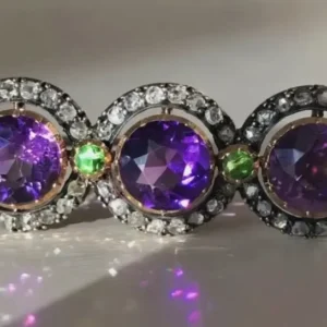A close up of a ring with purple and green stones