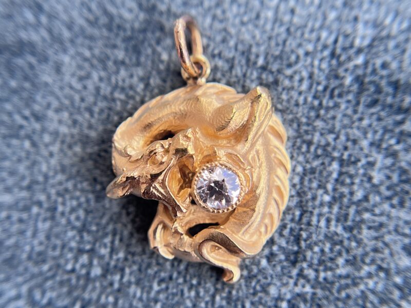 Gold dragon pendant with embedded gemstone.