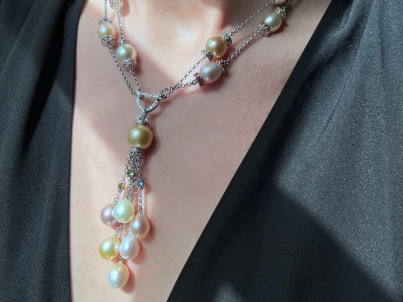 Pearl necklace on person wearing black top.