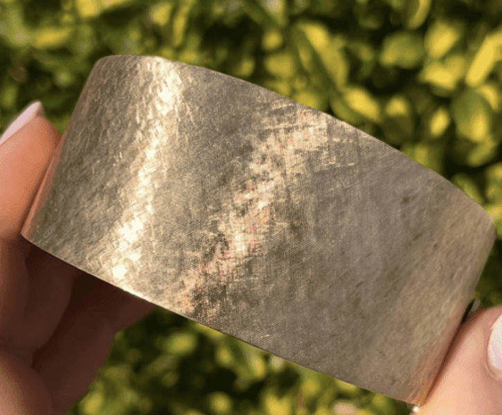 A person holding onto a gold bracelet