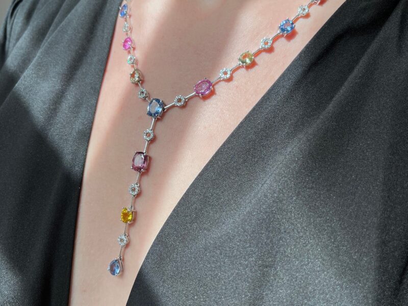 Necklace with colorful gemstones on black dress.