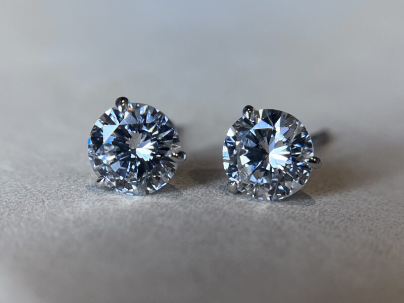 Diamond stud earrings on grey background.