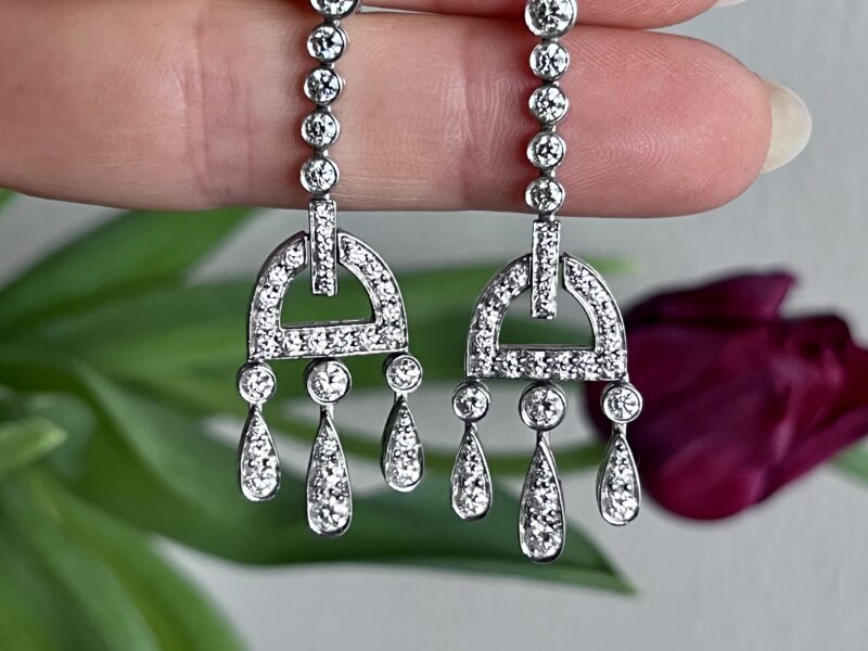 Silver earrings with diamond accents displayed.
